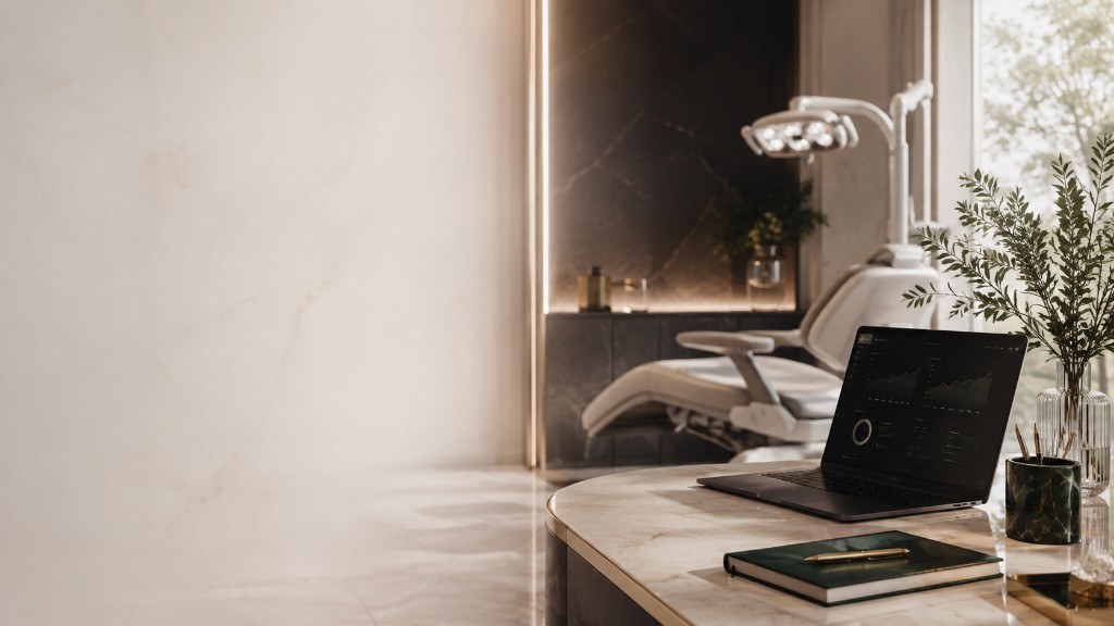 Quiet premium consultation room — marble desk, warm light and a considered dental chair
